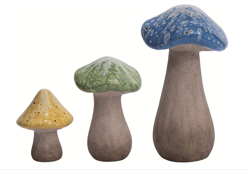 Three ceramic mushrooms with different colored caps on a white background