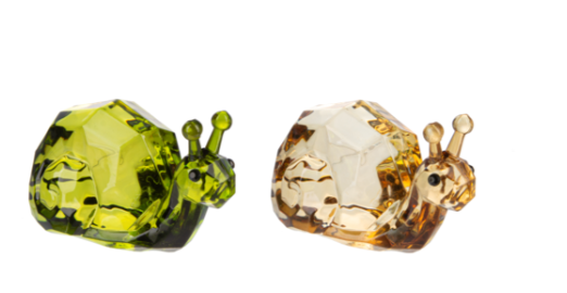 Two glass snail figurines, one green and one brown, on a white background