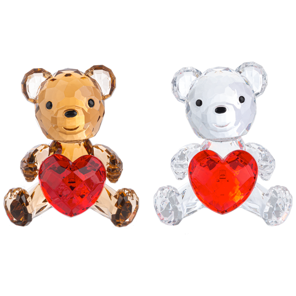 Two faceted crystal teddy bear ornaments holding red heart-shaped crystals, one in amber-brown and one in clear white, shown side by side on a white background.
