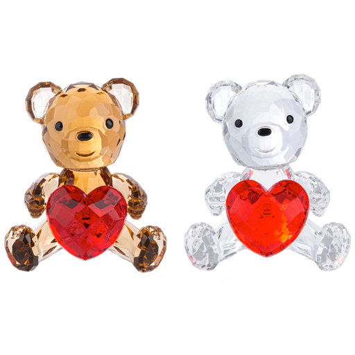 Two faceted crystal teddy bear ornaments holding red heart-shaped crystals, one in amber-brown and one in clear white, shown side by side on a white background.