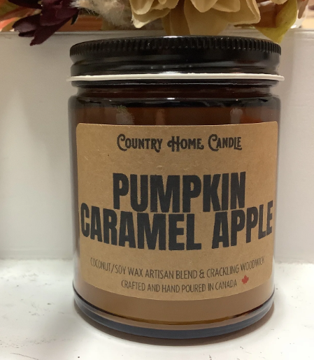 Jar of 'Pumpkin Caramel Apple' candle with a brown label on a white surface.