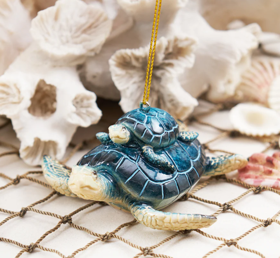 Decorative turtle ornament on a textured surface with shells in the background