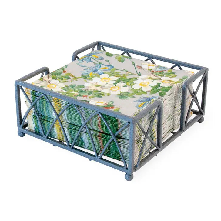 Metallic napkin holder with floral-patterned napkins on a white background