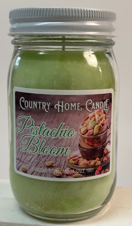 Green candle in a glass jar with a metal lid, featuring a 'Country Home Candle' label.