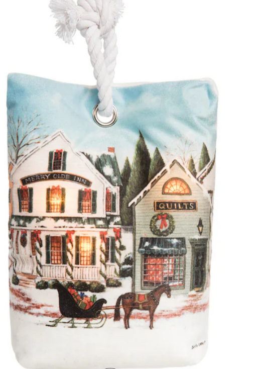 Decorative ornament with a winter scene of a town, houses, and a horse-drawn sleigh.