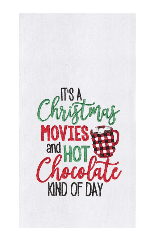 A white flour sack towel with red and green Christmas-themed text and a plaid design.