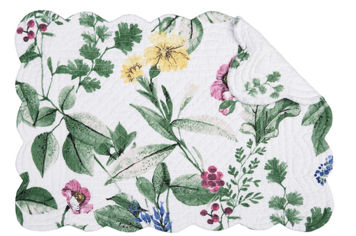 A white quilted placemat with floral print in green, pink, yellow
