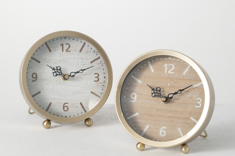 Two round alarm clocks with gold frames on a white background