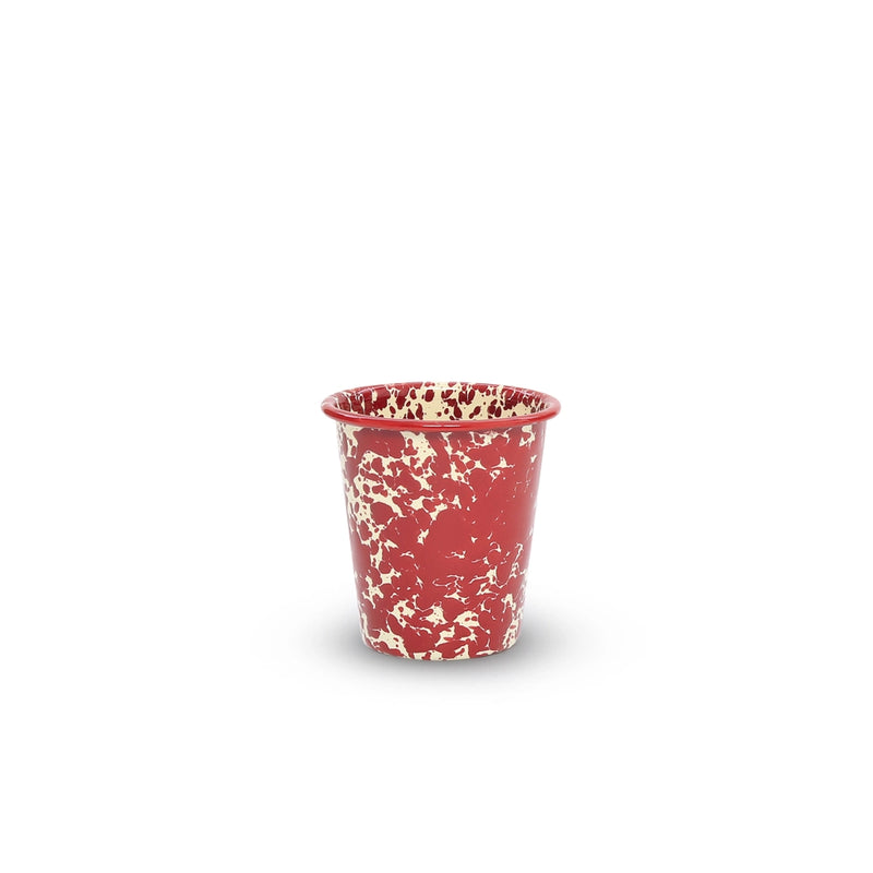 Red cup with white speckled pattern on a white background