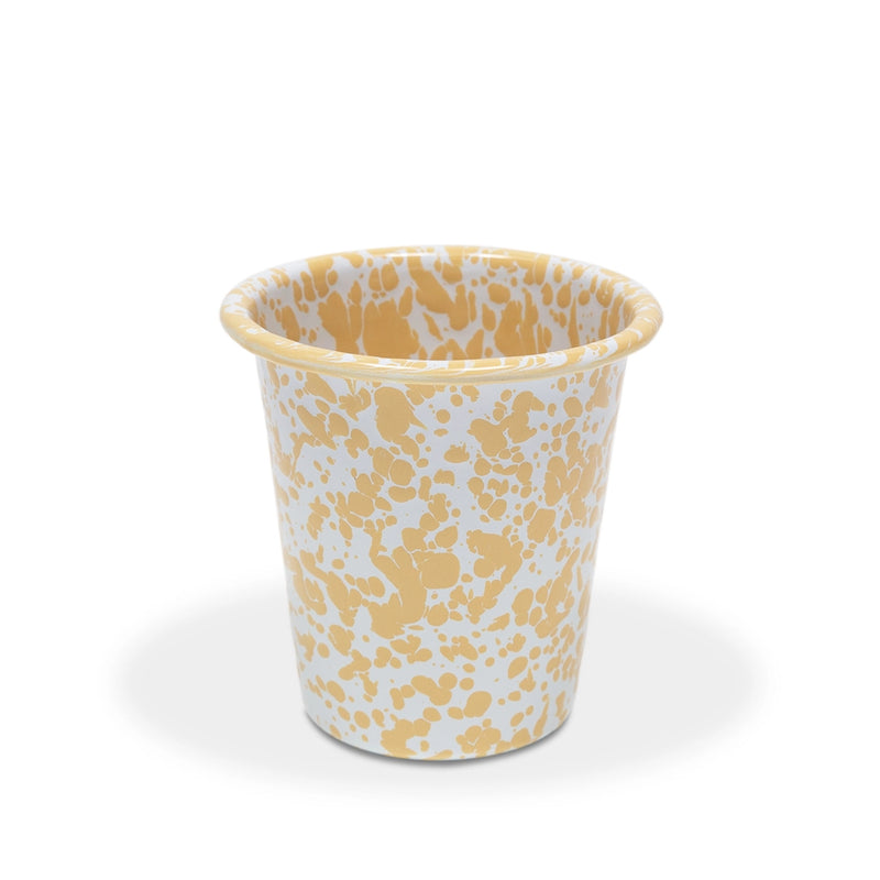 Enamel cup with yellow abstract pattern on a white background
