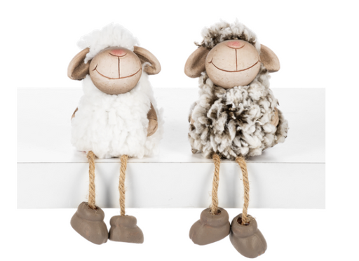 Two decorative sheep figurines with smiling faces on a white background