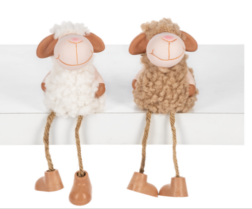 Two decorative sheep figurines on a white shelf