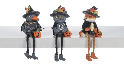 Three Halloween-themed figurines with black hats and pumpkin decorations on a white surface.