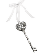 Decorative key with heart-shaped top and chain, tied with a white ribbon on a white background