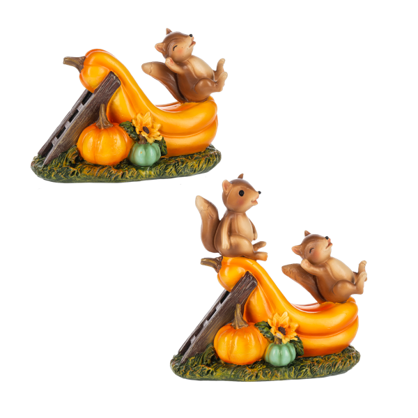 Two identical decorative figurines of squirrels sliding down a curved orange structure on a base with pumpkins, a green gourd, and a sunflower, shown on a plain white background.