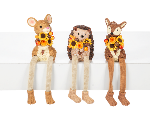 Three knitted animal dolls, resembling a deer, hedgehog, and rabbit, each holding a wreath of flowers on a white background.