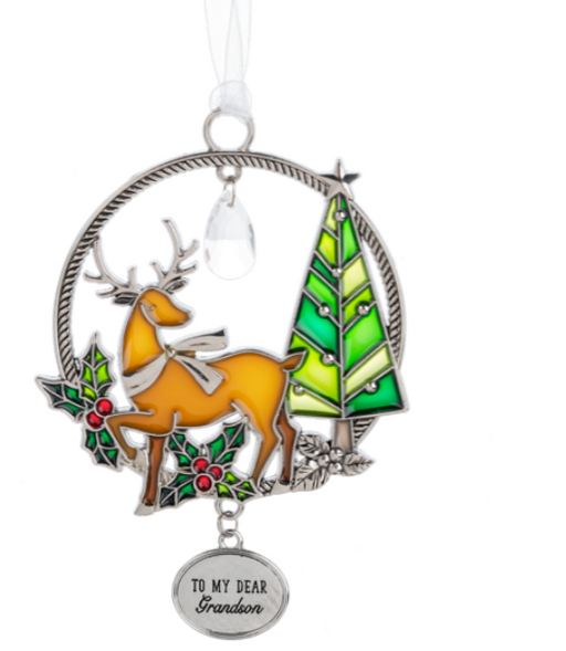 Decorative Christmas ornament with a deer, tree, and holly design on a white background.