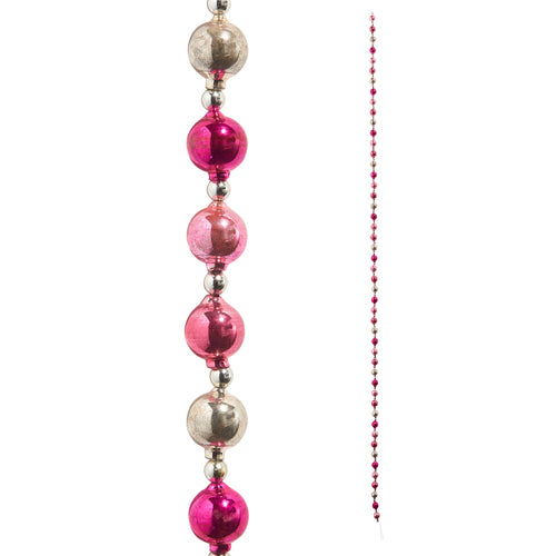 A pink and silver vintage ornament garland with spherical and oval-shaped decorations strung on a string.