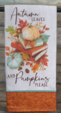 Decorative towel with autumn leaves and pumpkins design on a wooden surface