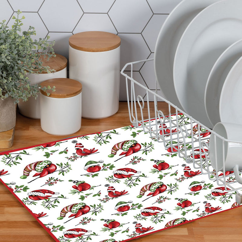 Christmas-themed placemat with red and green designs on a kitchen floor.