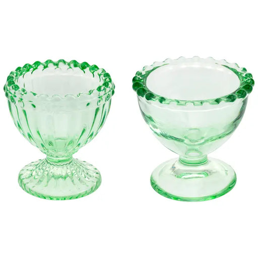 Two green glass dessert dishes on a white background