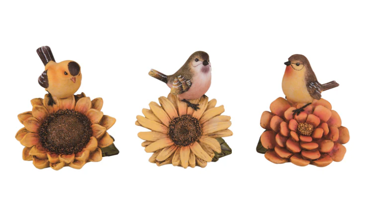 Three decorative figurines of birds on flowers with a white background