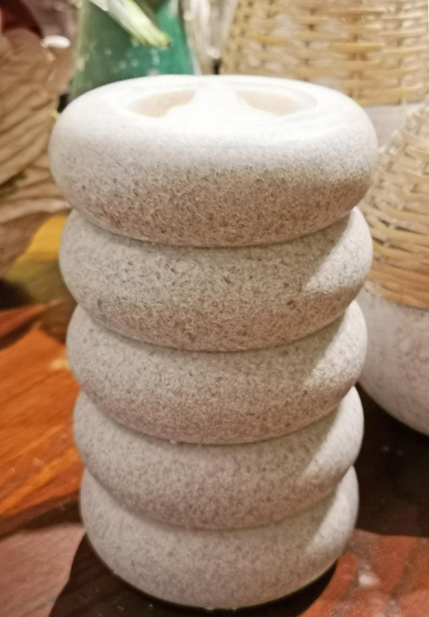 Stack of textured stone-like candle on a wooden surface