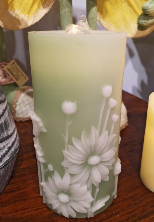 Decorative candle with floral design on a wooden surface