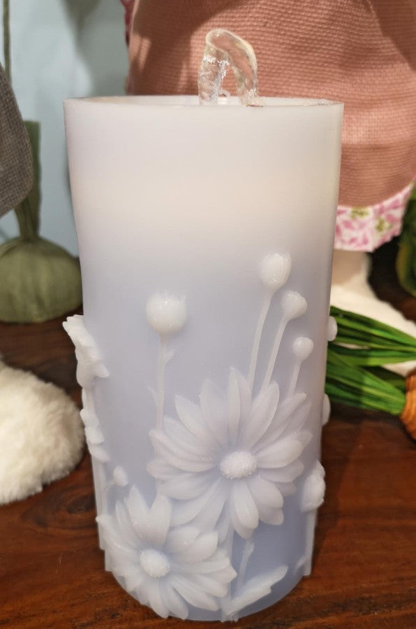 Decorative candle with floral design on a wooden surface