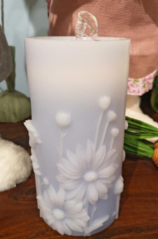 Decorative candle with floral design on a wooden surface
