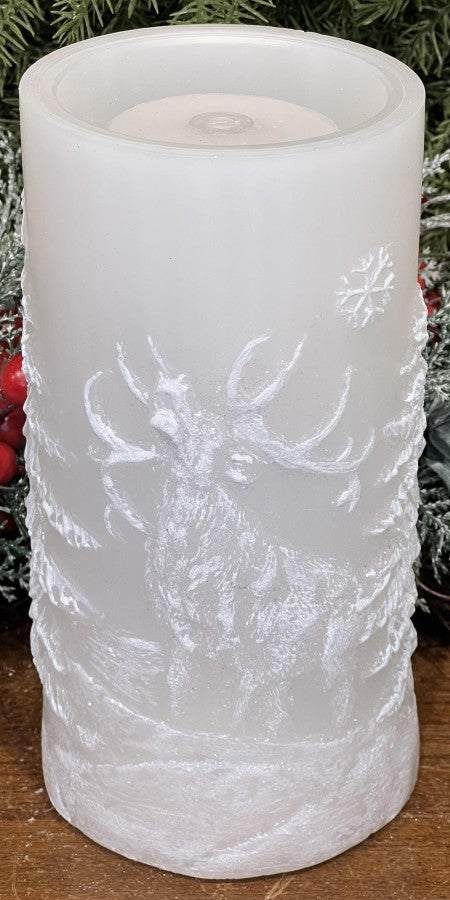 White cylindrical LED candle with mountain and snowflake design on a wooden surface.