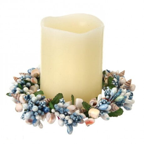 Decorative candle with a wreath of seashells and berries on a white background