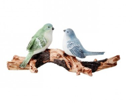 Two ceramic birds on a wooden branch against a white background