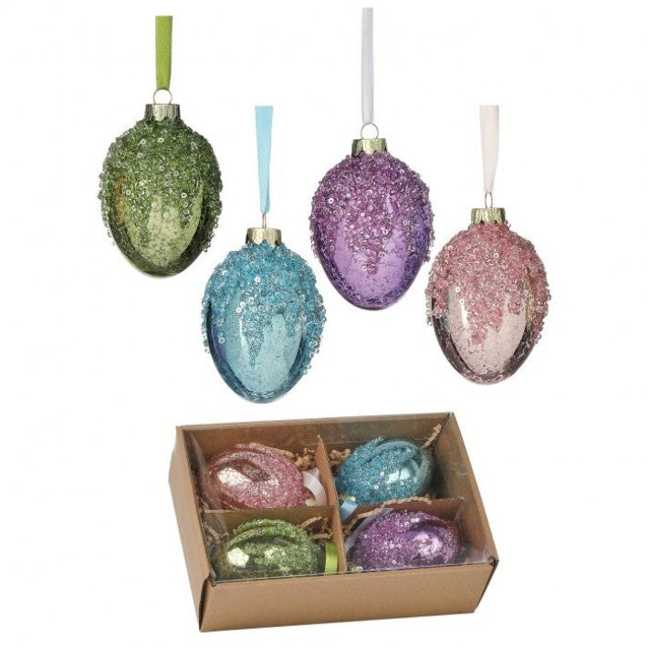 Set of colorful glittery egg-shaped Christmas ornaments with a cardboard box on a white background.