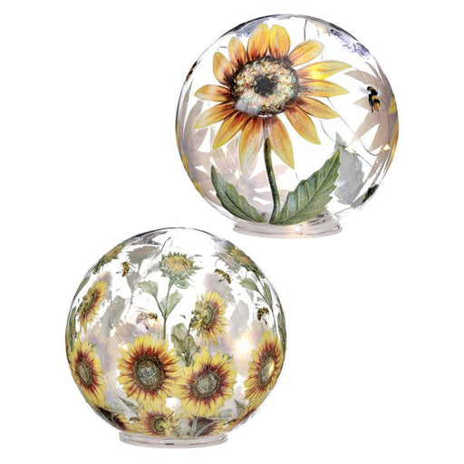 Two glass globes with sunflower designs on a white background