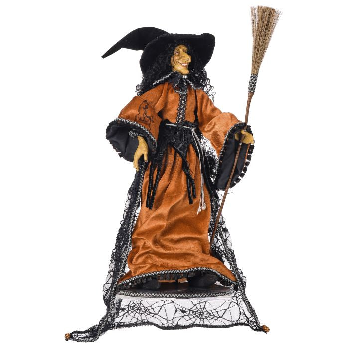 Halloween witch figurine with broom on a white background