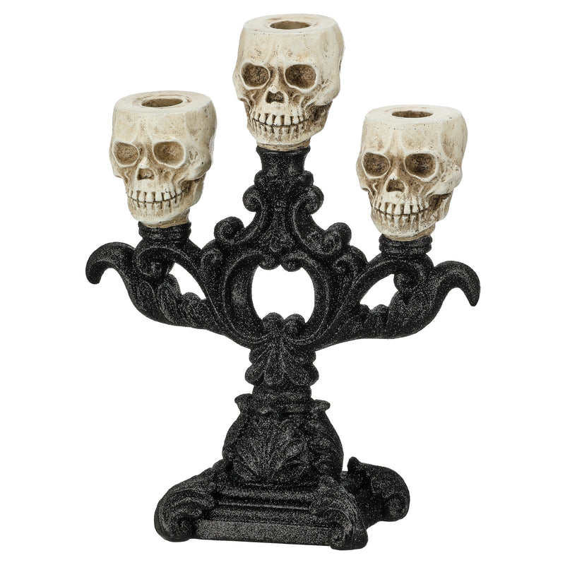 A gothic-style three-skelion candle holder with an ornate black metal base and three cream-colored skull candle cups, shown against a plain white background.