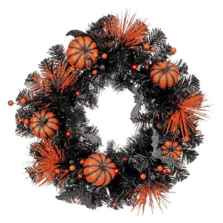 An autumn-themed artificial wreath featuring black frosted pine branches, bright orange faux pumpkins, orange pinecones, and orange glittery pinebrush accents, isolated on a white background.