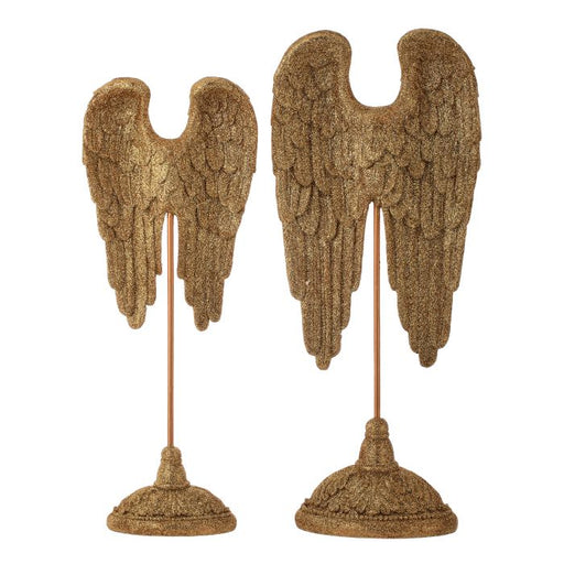 Pair of decorative angel wings on stands with a textured, gold-like finish against a white background.