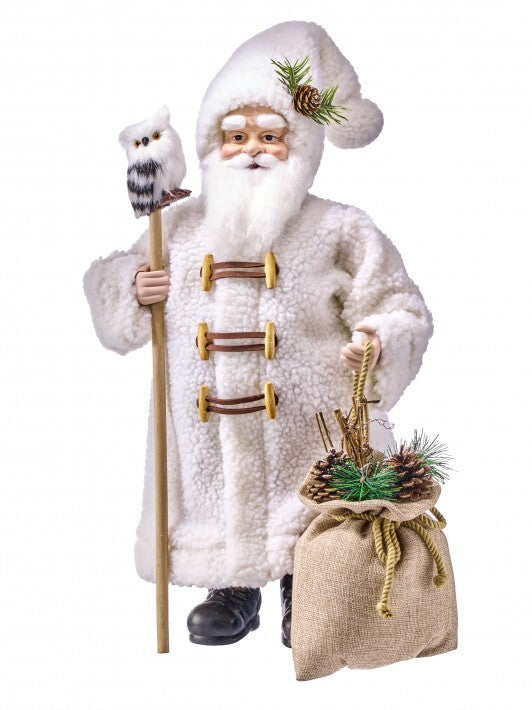 A Santa Claus figure or costume in a fluffy white faux-fur coat with brown toggle closures, holding a staff topped with an owl and carrying a burlap sack with pinecones and greenery, isolated on a white background.