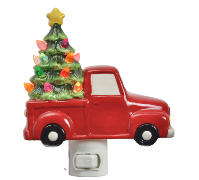 Decorative night light shaped like a red truck with a Christmas tree on a white background