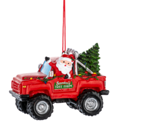 Christmas ornament of Santa driving a red truck with a tree, on a white background.