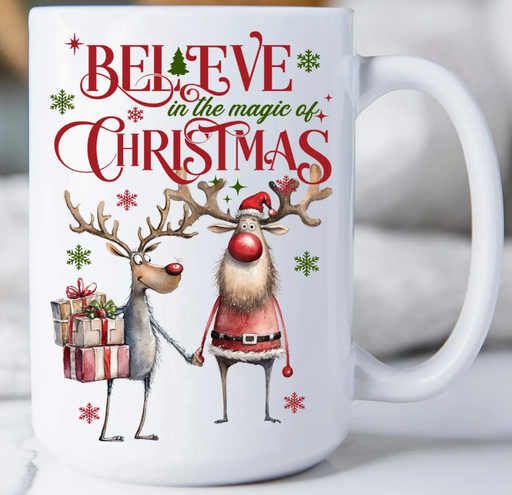 White mug with Christmas-themed design featuring two reindeer and text 'Believe in the magic of Christmas'.