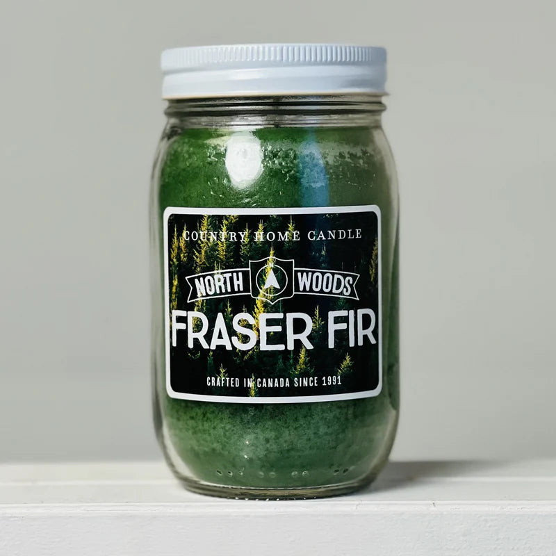 Jar of Fraser Fir candle with a North Woods label on a gray background