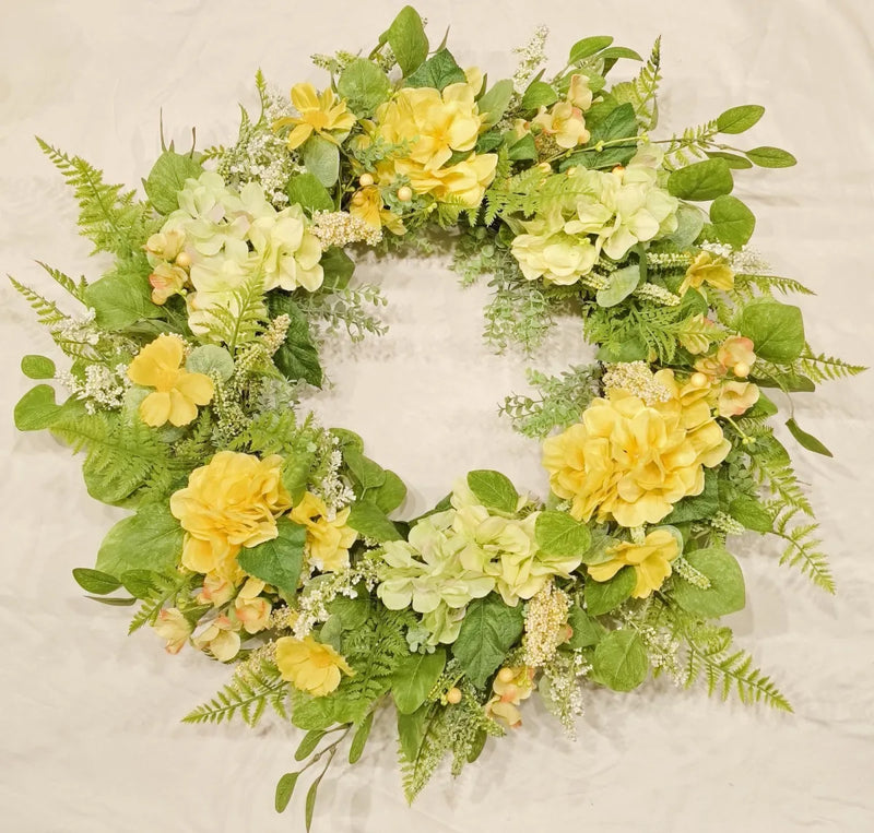 Floral wreath with yellow and green flowers on a textured beige background