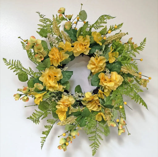 Floral wreath with yellow flowers and green leaves on a white background