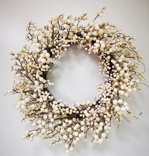 Decorative wreath with white berries on a plain background