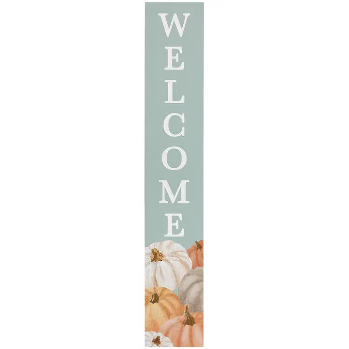 A tall, narrow vertical sign with the word 'WELCOME' in large white letters on a muted sage green background, with illustrated pumpkins in white, peach, orange, and gray at the bottom.