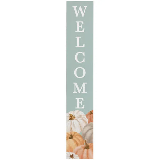A tall, narrow vertical sign with the word 'WELCOME' in large white letters on a muted sage green background, with illustrated pumpkins in white, peach, orange, and gray at the bottom.