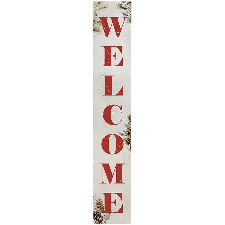 A vertical rectangular decorative sign with the word "WELCOME" in large distressed red letters on an off-white background, decorated with subtle pinecones and evergreen branches near the corners.
